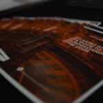 A stack of booklets titled "Casino Games: A Guide to Understanding the Odds" with a blurred roulette wheel image in the background. The booklets are arranged neatly on a dark surface.