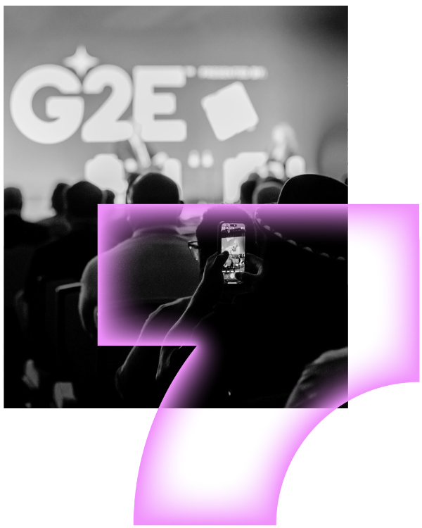 A grayscale photo of people at an event with a "G2E" sign on stage; one person is capturing the scene on their phone. A pink, translucent graphic overlay shaped like a stylized number 7 is in the foreground.